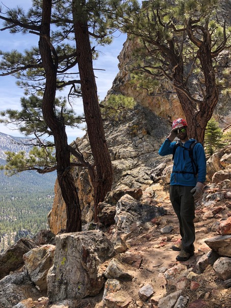 TRTA volunteer stands along possible new trail with clinometer at Castle Rock for massive trail rehabilitation project.